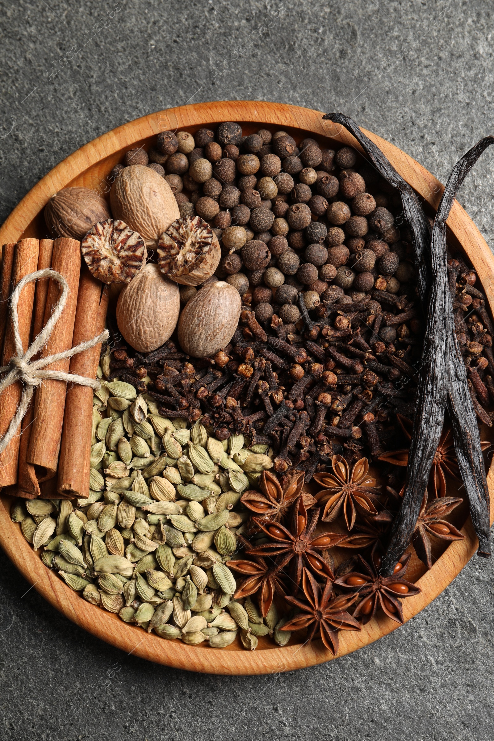 Photo of Different spices and nuts on gray table, top view