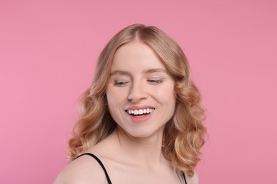 Photo of Portrait of beautiful woman with blonde hair on pink background