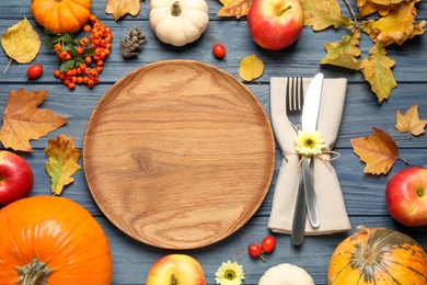 Photo of Flat lay composition with tableware, autumn fruits and vegetables on blue wooden background. Thanksgiving Day
