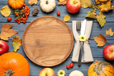 Flat lay composition with tableware, autumn fruits and vegetables on blue wooden background. Thanksgiving Day