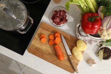 Homemade bouillon recipe. Fresh ingredients on countertop near cooktop, flat lay