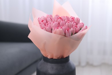 Photo of Bouquet of beautiful pink tulips in vase indoors, closeup