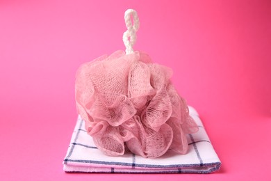 New shower puff and towel on pink background