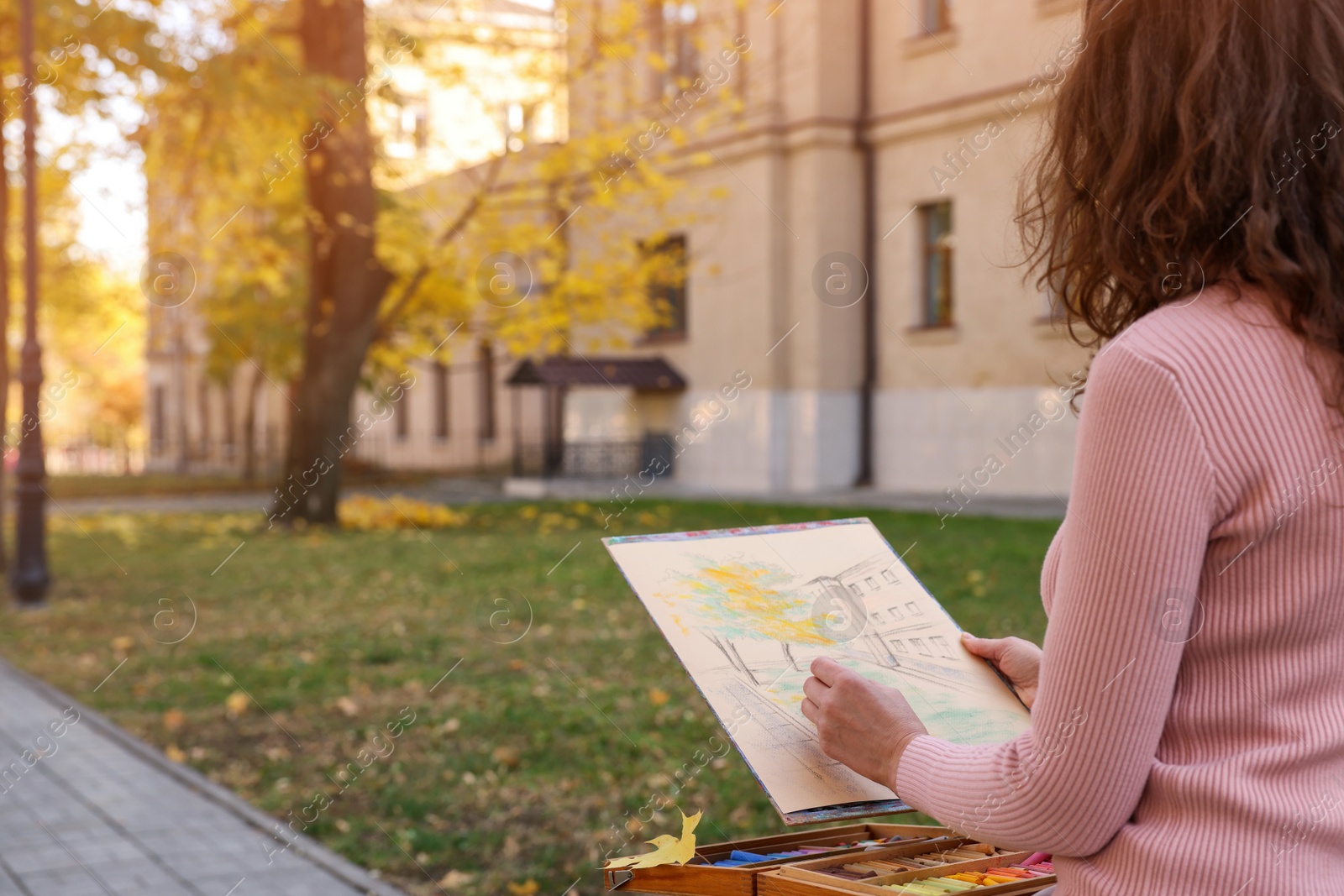 Photo of Woman drawing with soft pastels on street