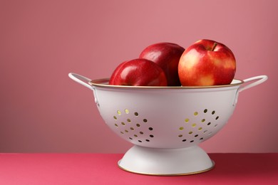 Photo of Colander with fresh apples on color background