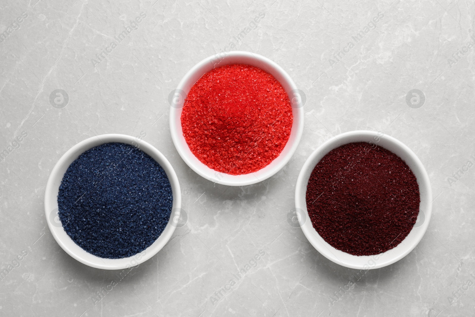 Photo of Different food coloring on light grey marble table, flat lay