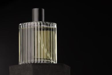 Photo of Luxury men`s perfume in bottle against dark background, space for text