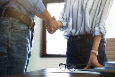 Photo of Business partners shaking hands after meeting, closeup