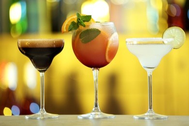 Row of different fresh alcoholic cocktails on bar counter