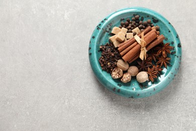 Photo of Different aromatic spices on light textured table, top view. Space for text