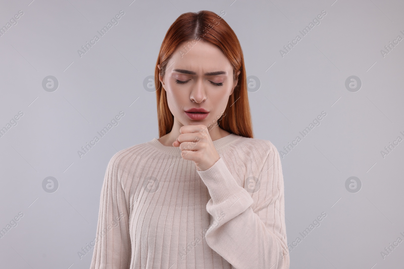 Photo of Woman coughing on light grey background. Cold symptoms