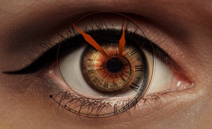 Image of Paranormality, supernatural or mental disorders concepts. Woman with weird eye, closeup. Clock hands and digits twisting into iris