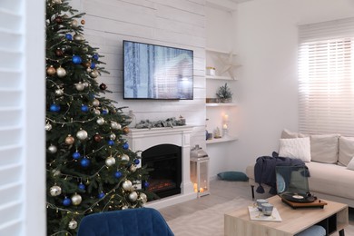 Photo of Stylish living room interior with modern TV, fireplace and Christmas tree