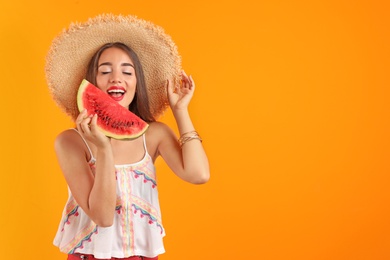 Beautiful young woman posing with watermelon on color background