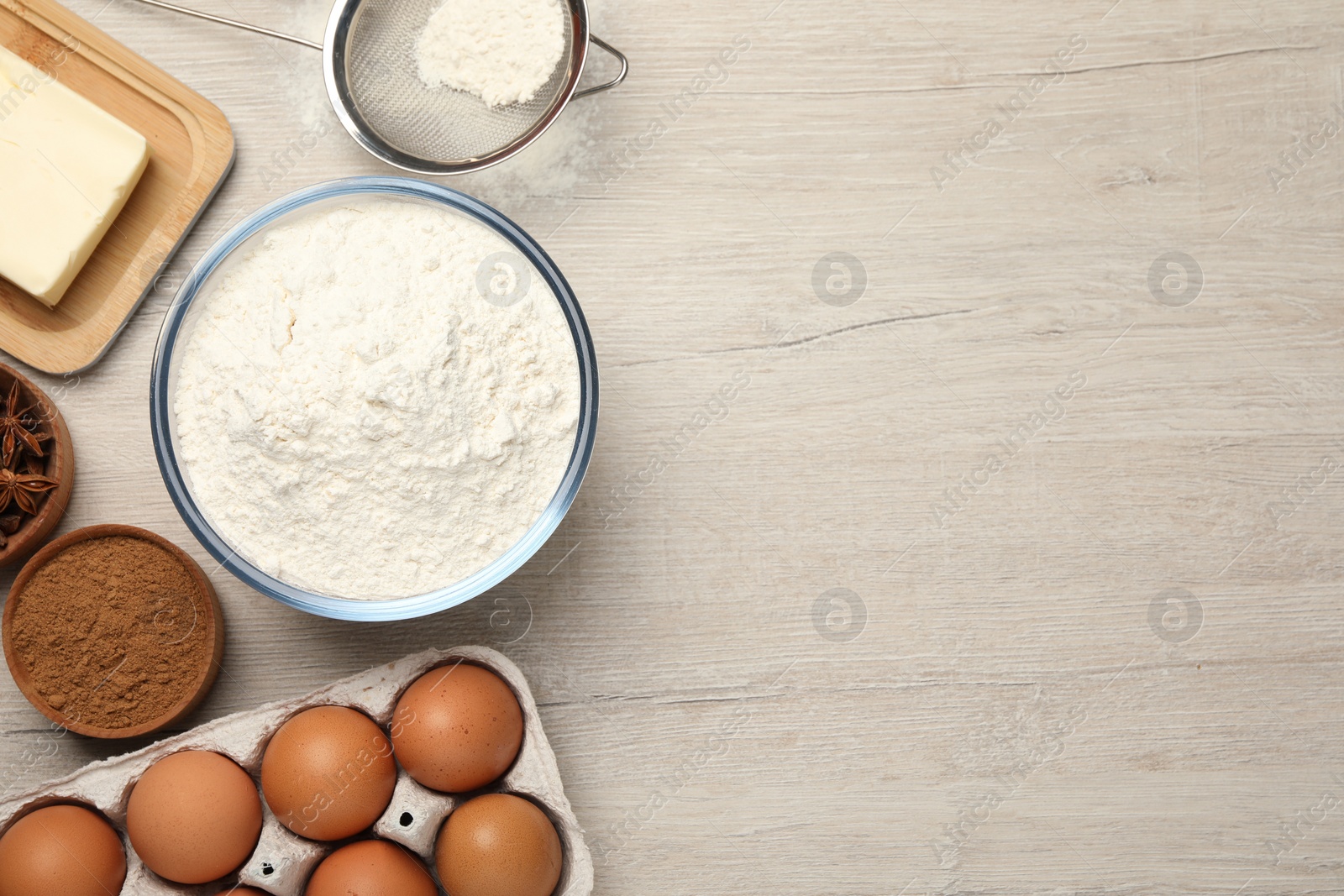 Photo of Flat lay composition with flour and different ingredients on white wooden table, space for text. Cooking yeast cake