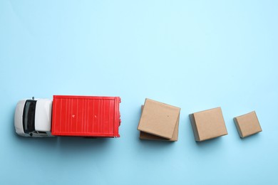 Photo of Top view of toy truck with boxes on blue background. Logistics and wholesale concept