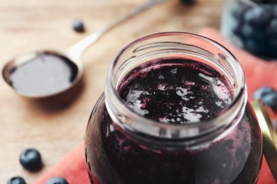 Photo of Jar of delicious blueberry jam, closeup view