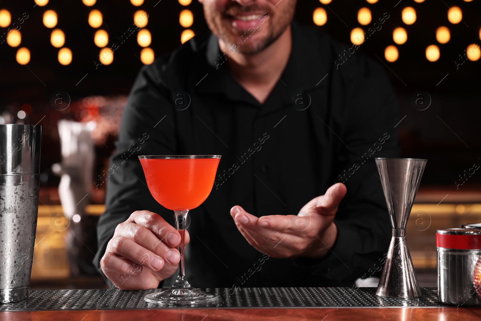 Photo of Bartender with fresh alcoholic cocktail in bar, closeup