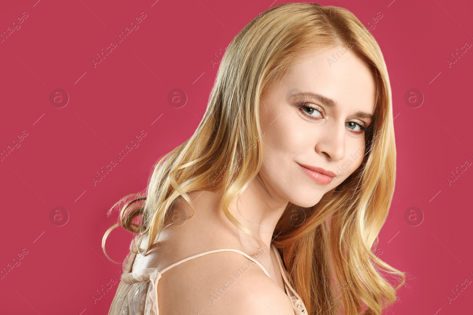 Photo of Portrait of beautiful young woman with dyed long hair on pink background