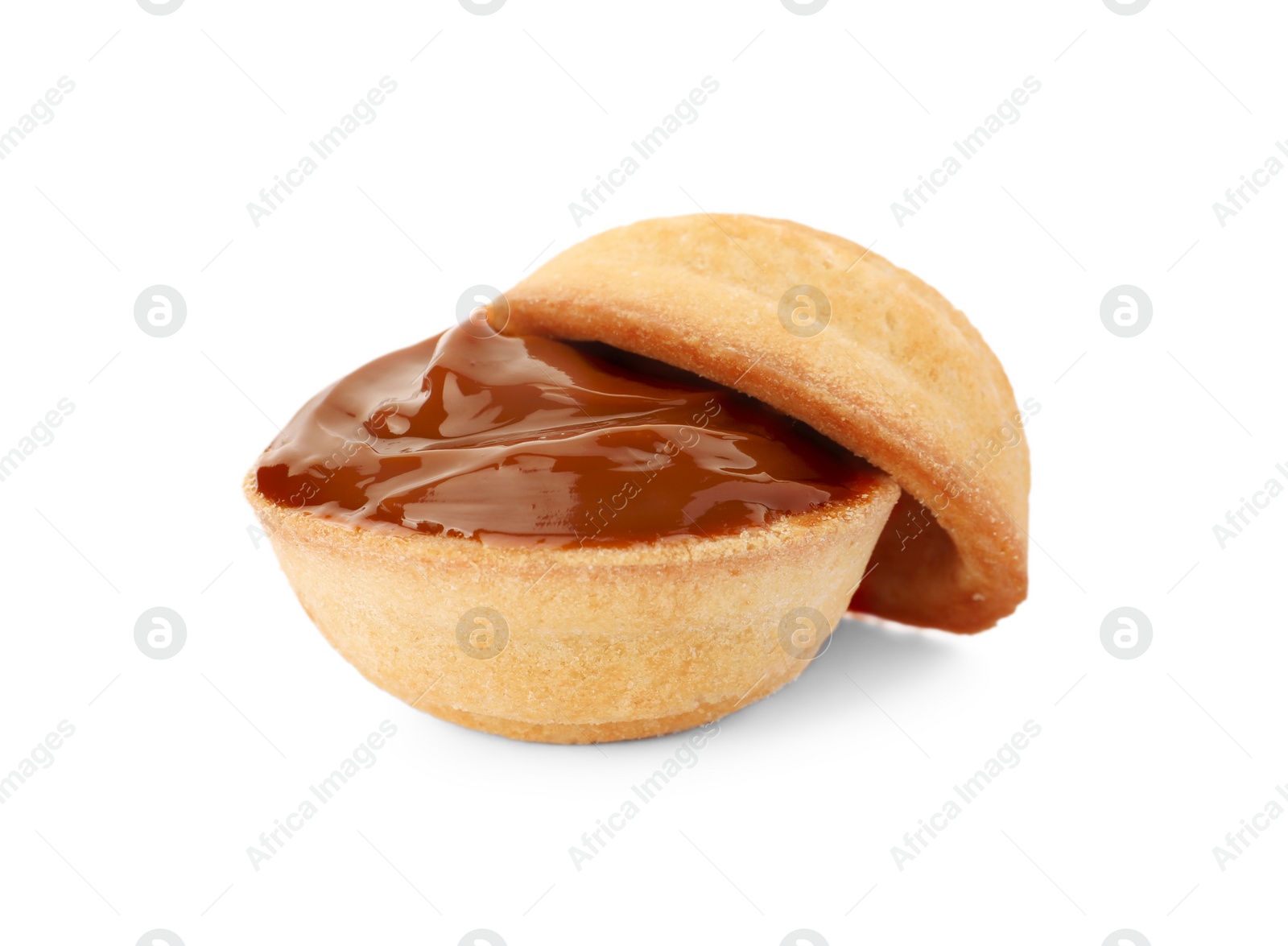 Photo of Halves of delicious nut shaped cookie with boiled condensed milk on white background