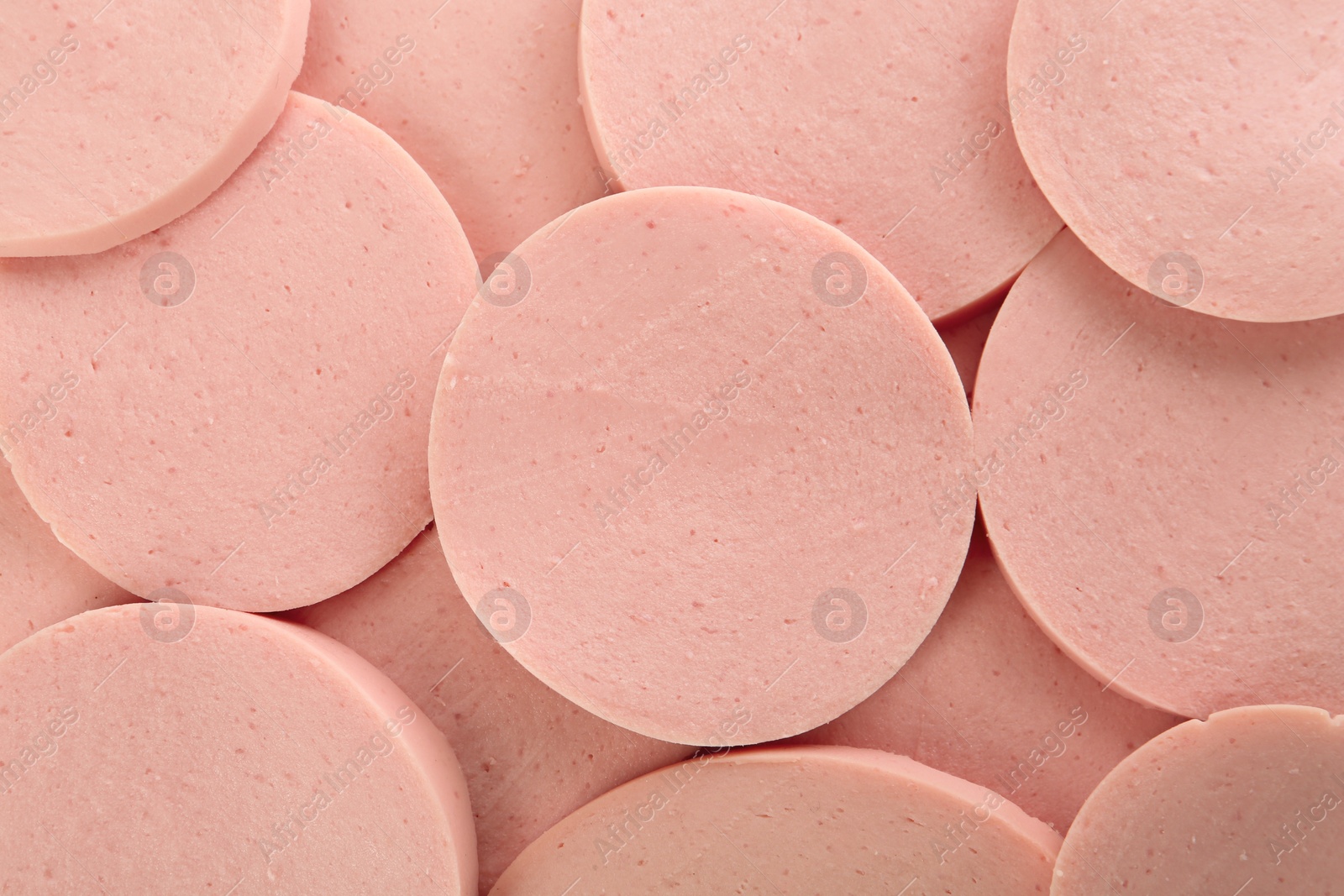 Photo of Slices of tasty boiled sausage as background, top view