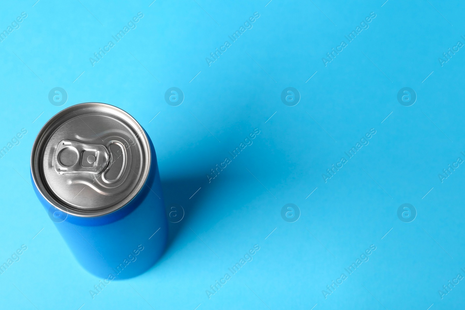 Photo of Energy drink in can on light blue background, above view. Space for text