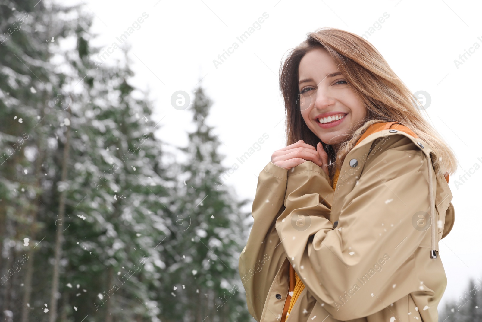 Photo of Young woman in warm clothes outdoors on snowy day, space for text. Winter vacation