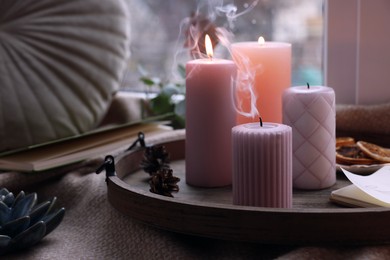 Tray with wax candles on window sill indoors