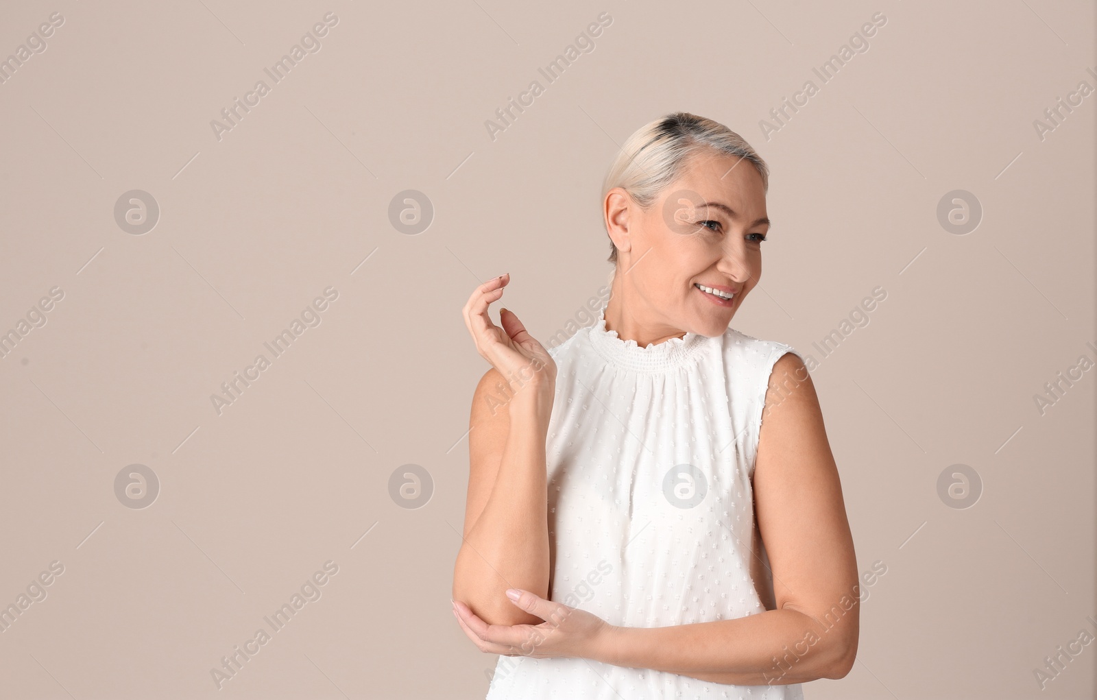 Photo of Portrait of beautiful mature woman on beige background. Space for text