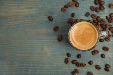 Cup of tasty coffee on blue wooden table, flat lay. Space for text