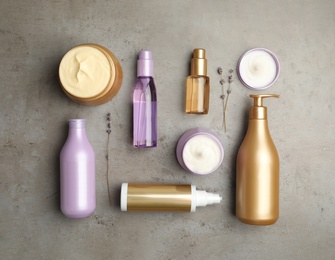 Photo of Flat lay composition with hair care cosmetic products on grey stone table