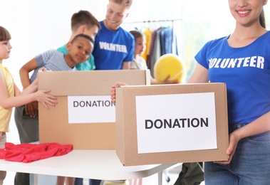 Photo of Volunteers with children sorting donation goods indoors