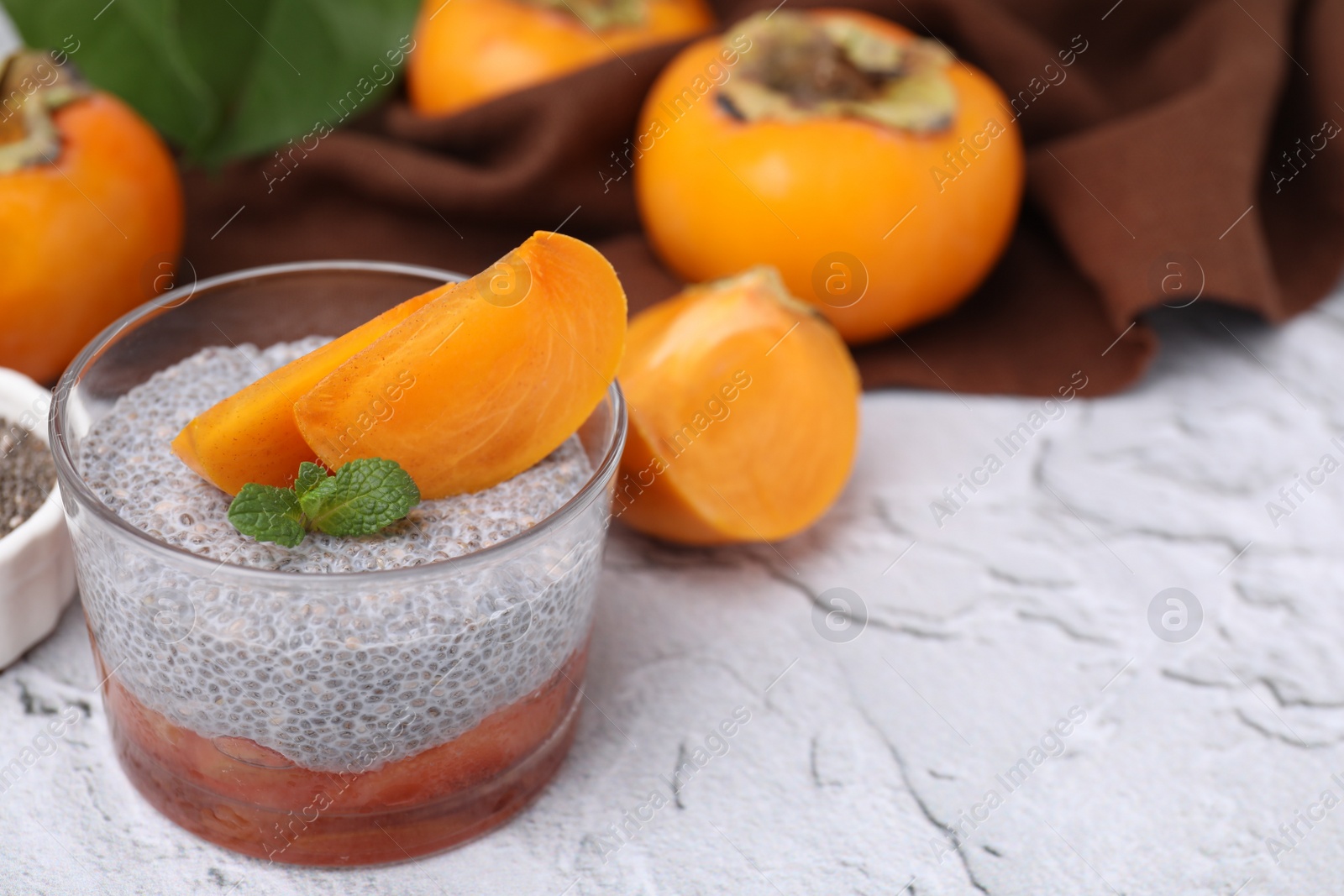 Photo of Delicious dessert with persimmon and chia seeds on table