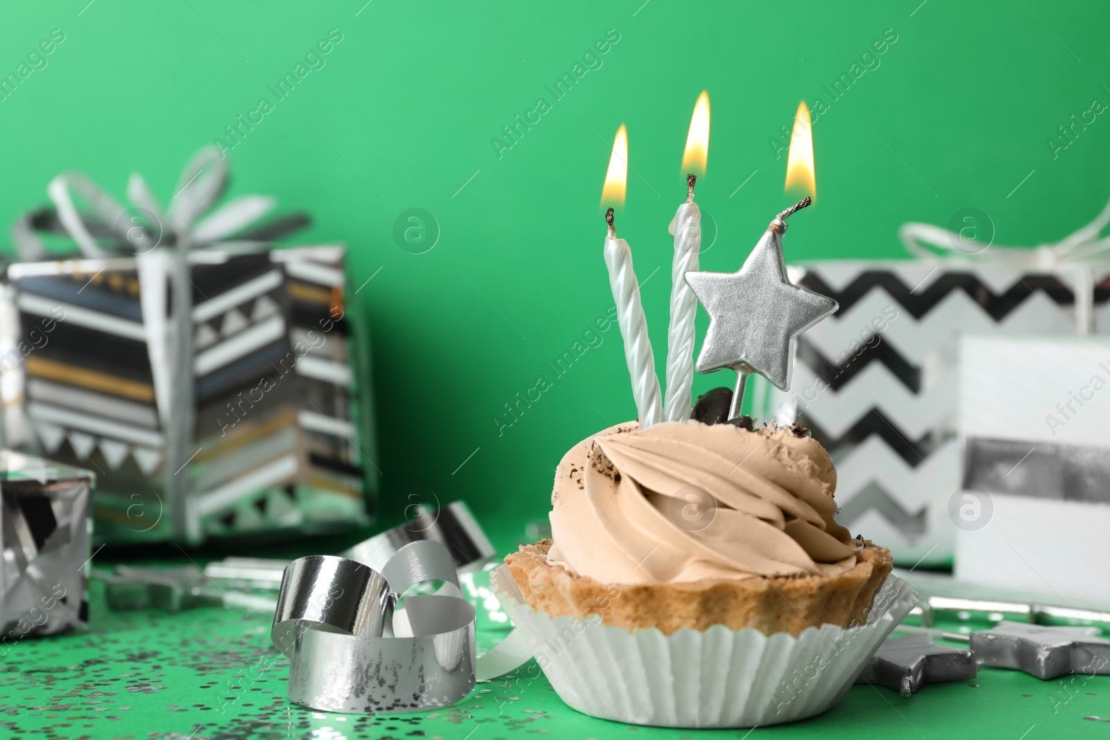 Photo of Birthday cupcake with candles on green background
