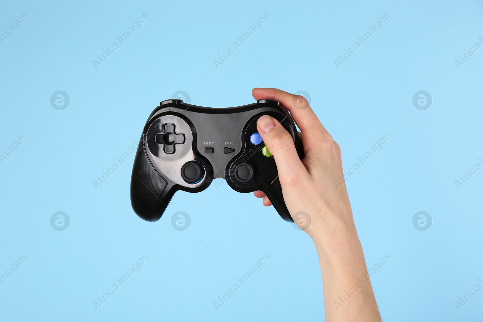 Photo of Woman with game controller on light blue background, closeup