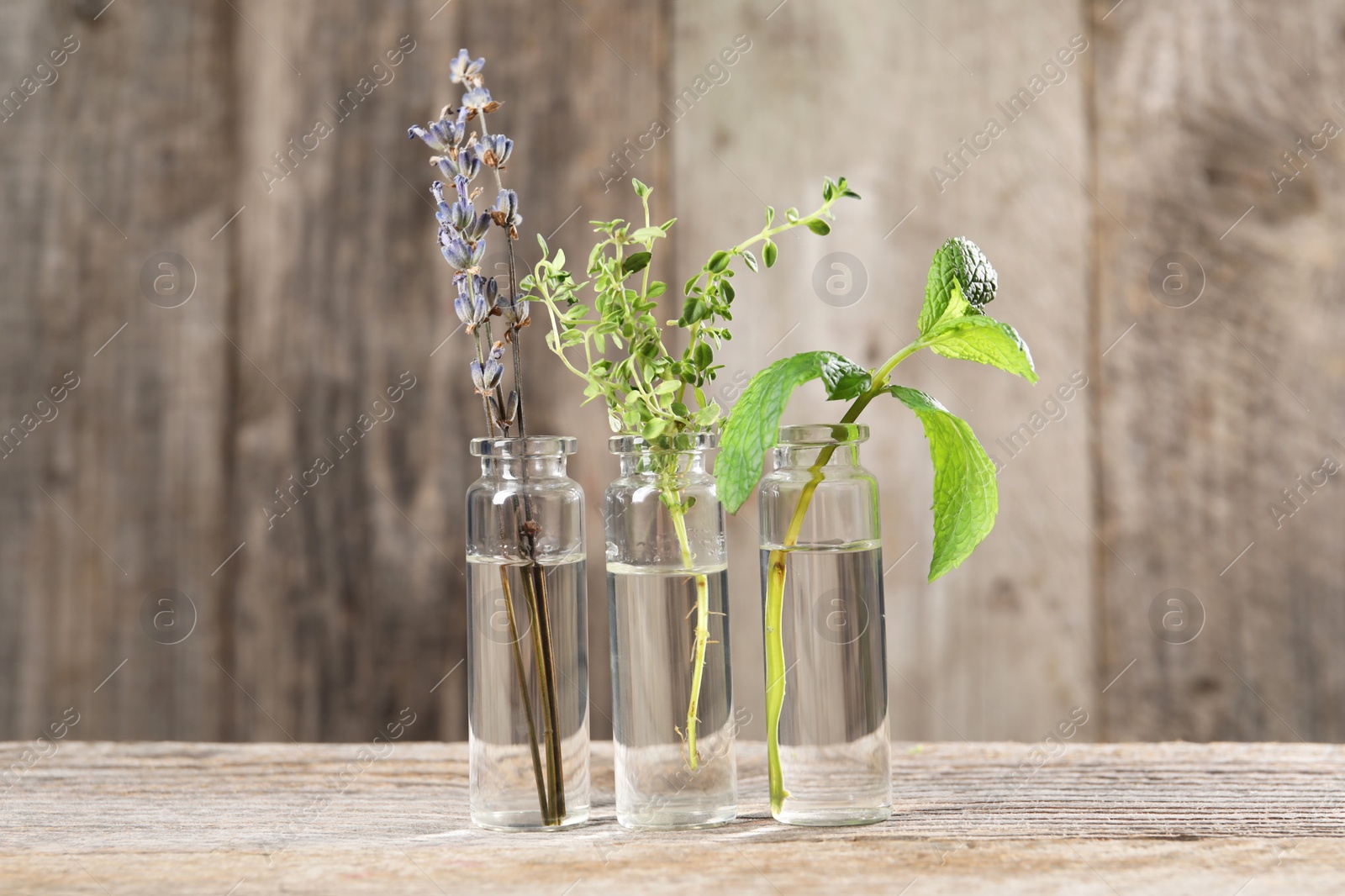 Photo of Bottles with essential oils and plants on wooden table