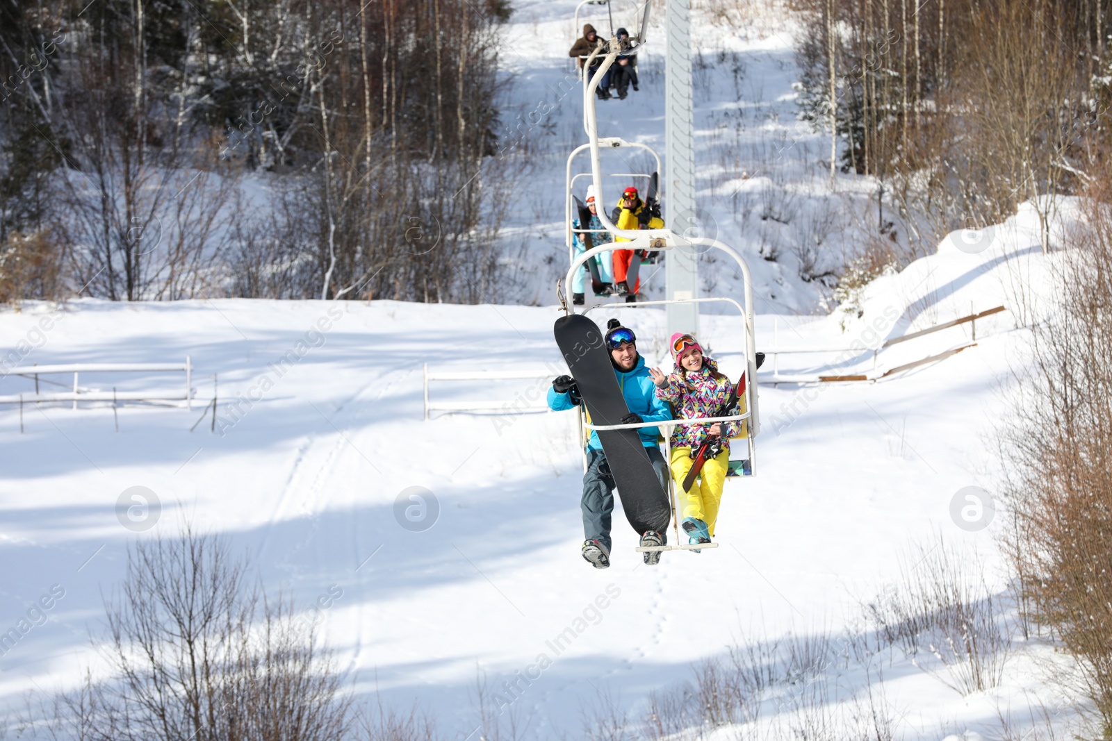 Photo of Couple using chairlift at mountain ski resort. Winter vacation