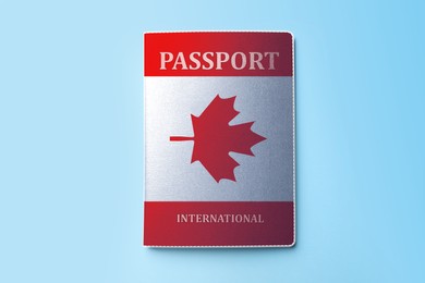 Passport in case with image of Canadian flag on light blue background, top view