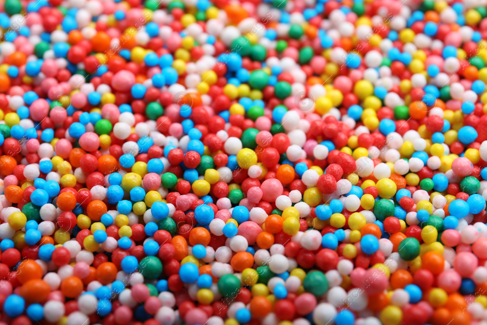 Photo of Bright colorful sprinkles as background, closeup. Confectionery decor