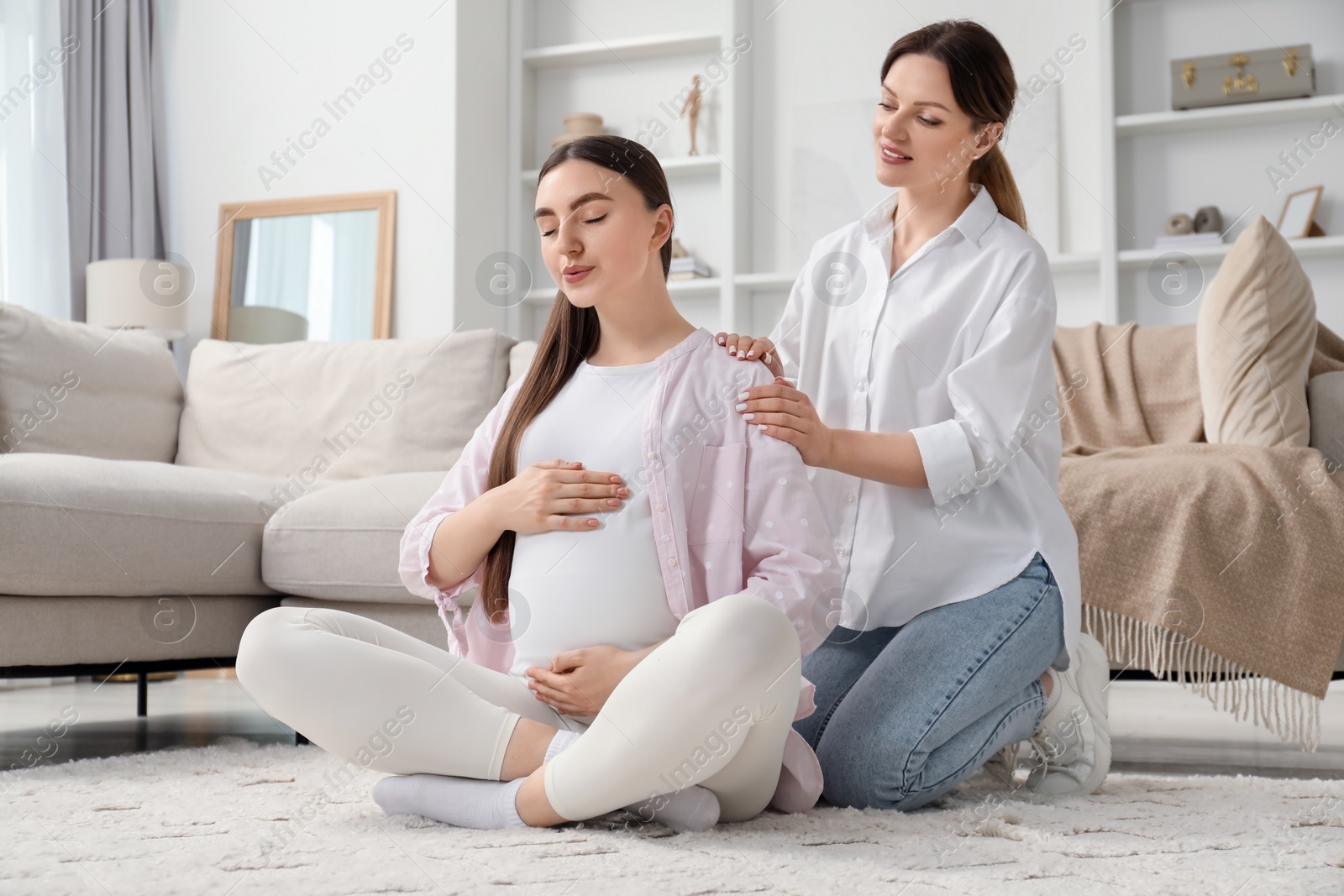 Photo of Doula taking care of pregnant woman at home. Preparation for child birth