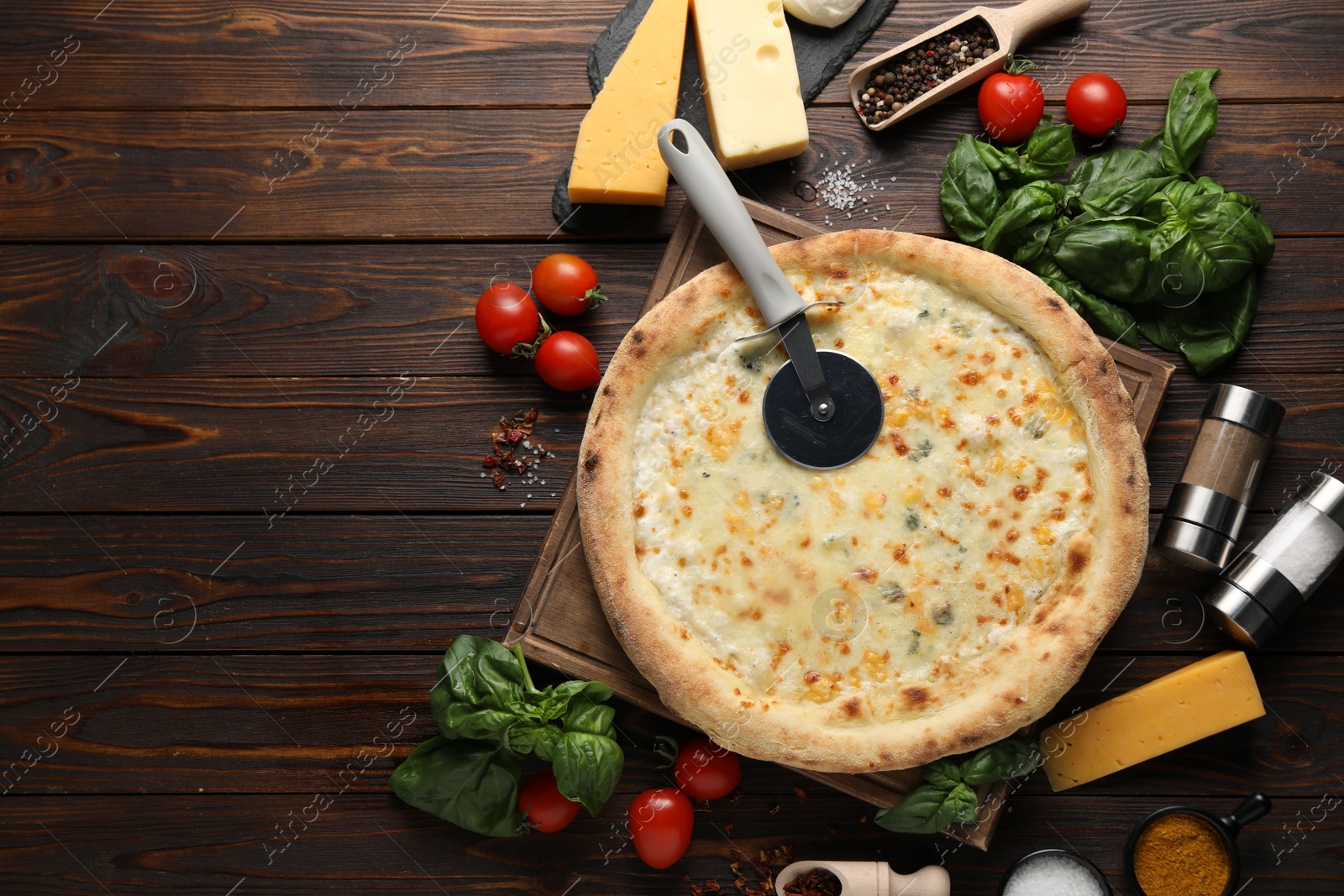 Photo of Flat lay composition with delicious cheese pizza and ingredients on wooden table. Space for text