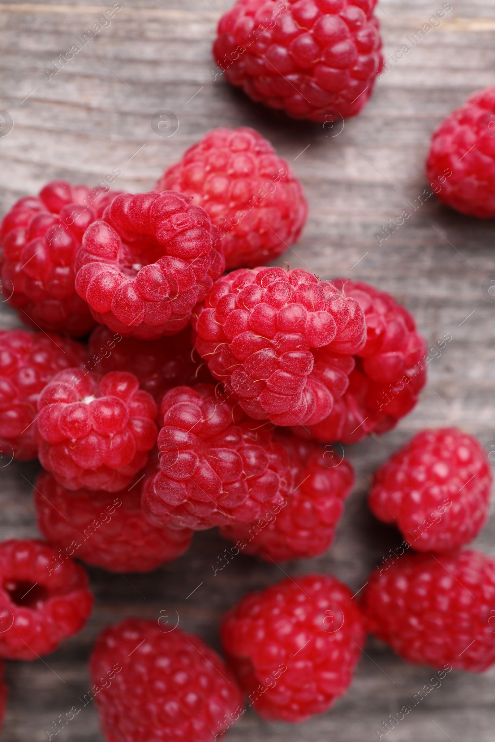 Photo of Tasty ripe raspberries on wooden table, top view