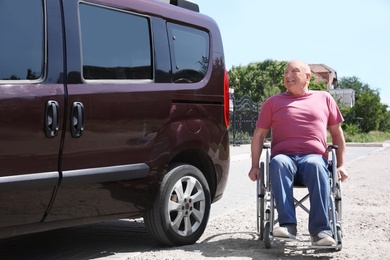 Photo of Senior man in wheelchair near van outdoors