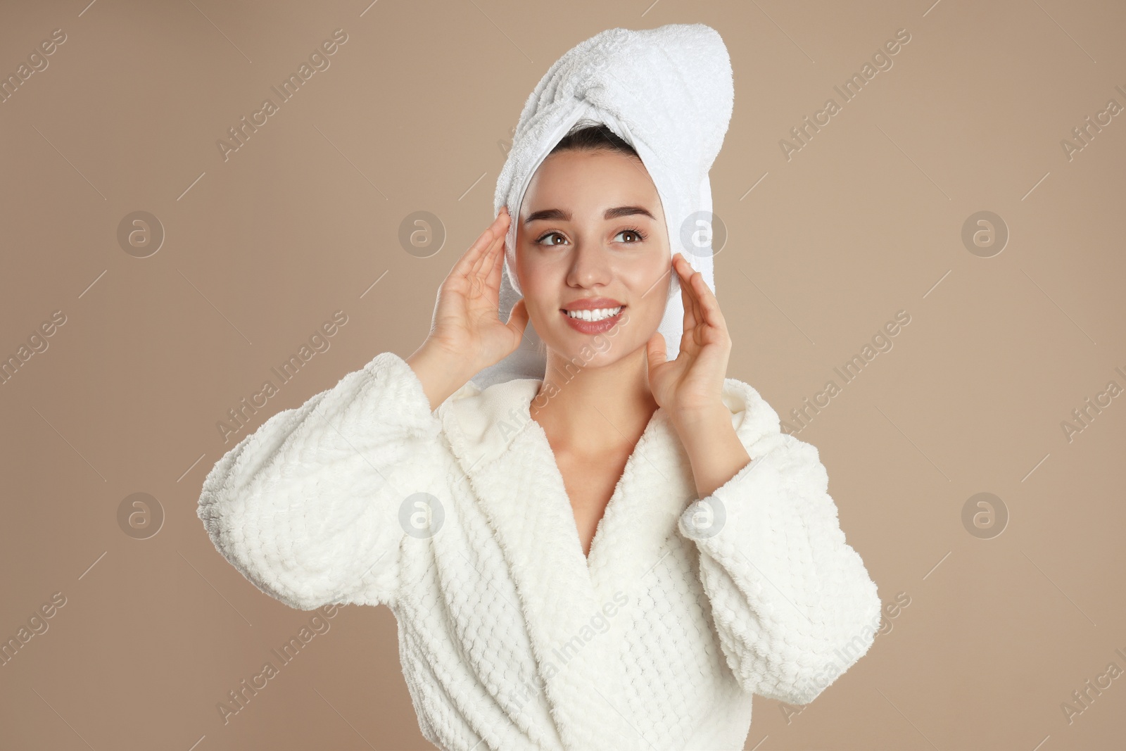 Photo of Beautiful young woman in bathrobe on brown background