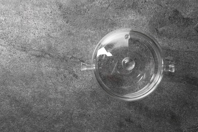 Glass pot with lid on grey table, top view. Space for text