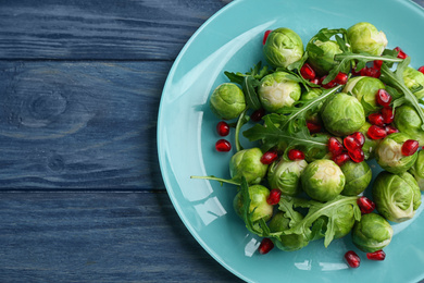 Photo of Tasty salad with Brussels sprouts on wooden table, top view. Space for text