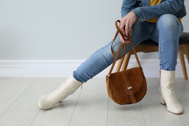 Woman in stylish leather shoes with bag indoors, closeup. Space for text