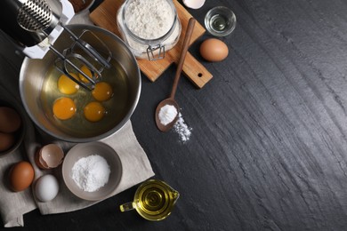 Photo of Making dough. Raw eggs in bowl of stand mixer and ingredients on black table, flat lay with space for text