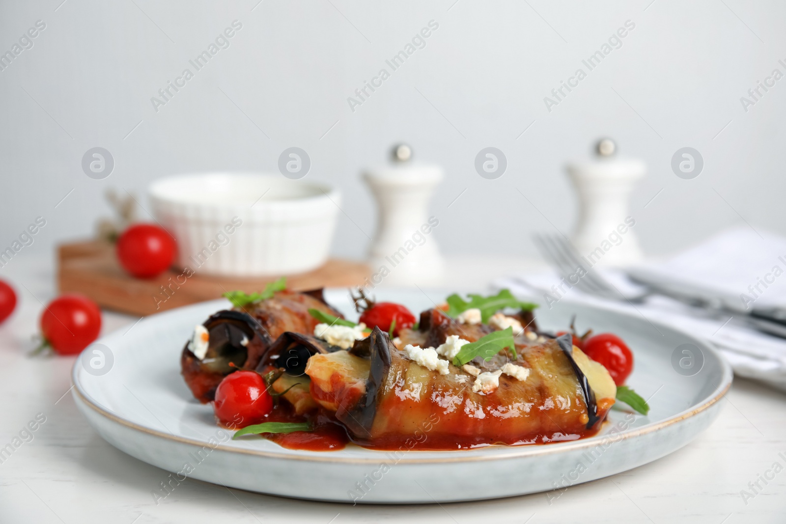 Photo of Delicious baked eggplant rolls served on white wooden table