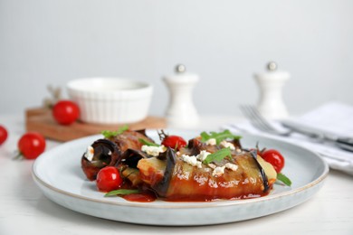 Photo of Delicious baked eggplant rolls served on white wooden table